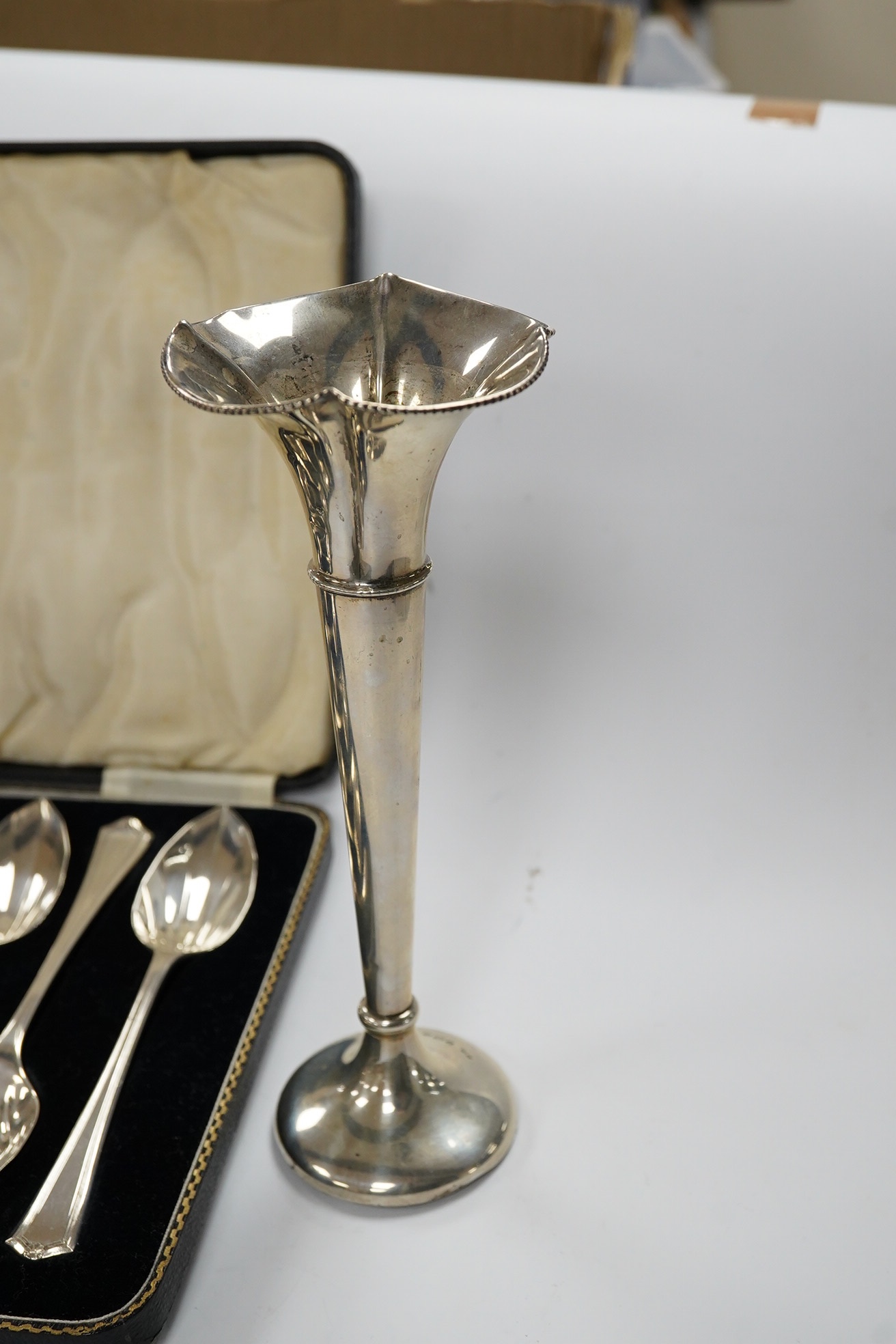 A cased set of eight George V silver grapefruit spoons, Sheffield, 1933 and a pair of silver spill vases, 17.5cm. Condition - poor to fair